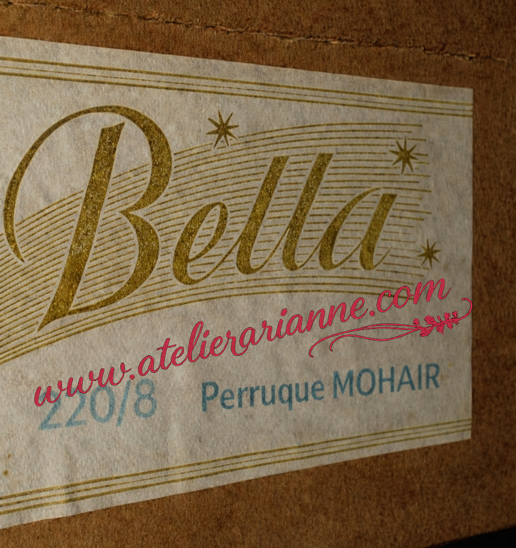 Bella réf. 220/8 — enquête d’identification — Bella 220/8, Bella ref 220/8 cheveux mohair, poupée Bella années 1950, Bella série 220 première génération, Bella période de transition 1954-1956, poupée corps carton travaillé, Bella corps carton bouilli, Bella avant alkatène, évolution morphologique Bella, Bella pré-Gros Cuisse, apparition du type Gros Cuisse, Bella transition industrielle, Bella sans marquage relief, Bella 38 cm années 50, poupée française vintage 1950, identification poupée Bella ancienne, analyse comparative série 220, Bella moule Paredes influence, morphologie intermédiaire Bella, comparaison Bella 220 précoce et tardive, Bella cheveux mohair authentique, perruque mohair poupée ancienne, Bella robe col Claudine, esthétique petite fille modèle années 50, Bella évolution des matériaux, Bella plastique précoce non rhodoïd, Bella phase hybride production, documentation partielle modèles Bella, variantes peu documentées Bella années 50, boîte originale Bella ref 220/8, correspondance boîte et poupée Bella, étude chronologique poupée française, recherche historique poupées françaises, manufacture française poupées années 50, Les Enquêtes d’Atelier Arianne, analyse muséale poupée ancienne, dossier d’identification poupée Bella — vue 22.