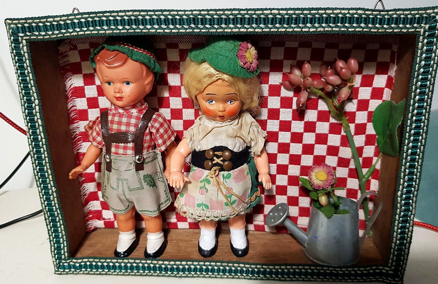 Deux dioramas miniatures avec des poupées ARI — créations de Sylvie — Vitrine au fond vichy rouge et blanc créée par Sylvie, avec deux poupées présentées comme des ARI et un arrosoir fleuri — vue 2.
