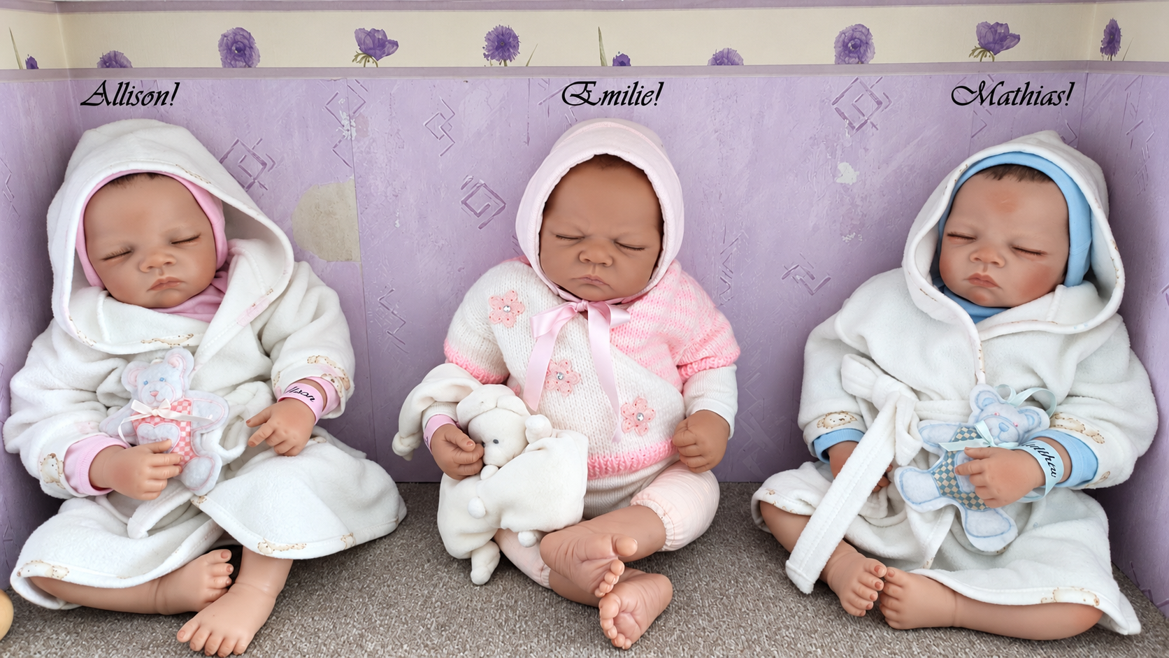 Bébés réalistes en vinyle — collection de Martine — Trois bébés endormis, vêtus de blanc, de rose et de bleu, installés côte à côte avec leurs petites peluches — vue 1.