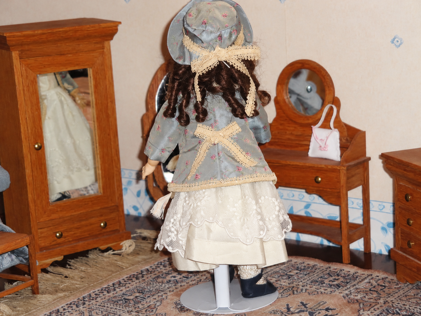 Poupée Goebel — tenue de soie — Vue de dos : chevelure bouclée, chapeau et nœud de dentelle de la veste — vue 2.