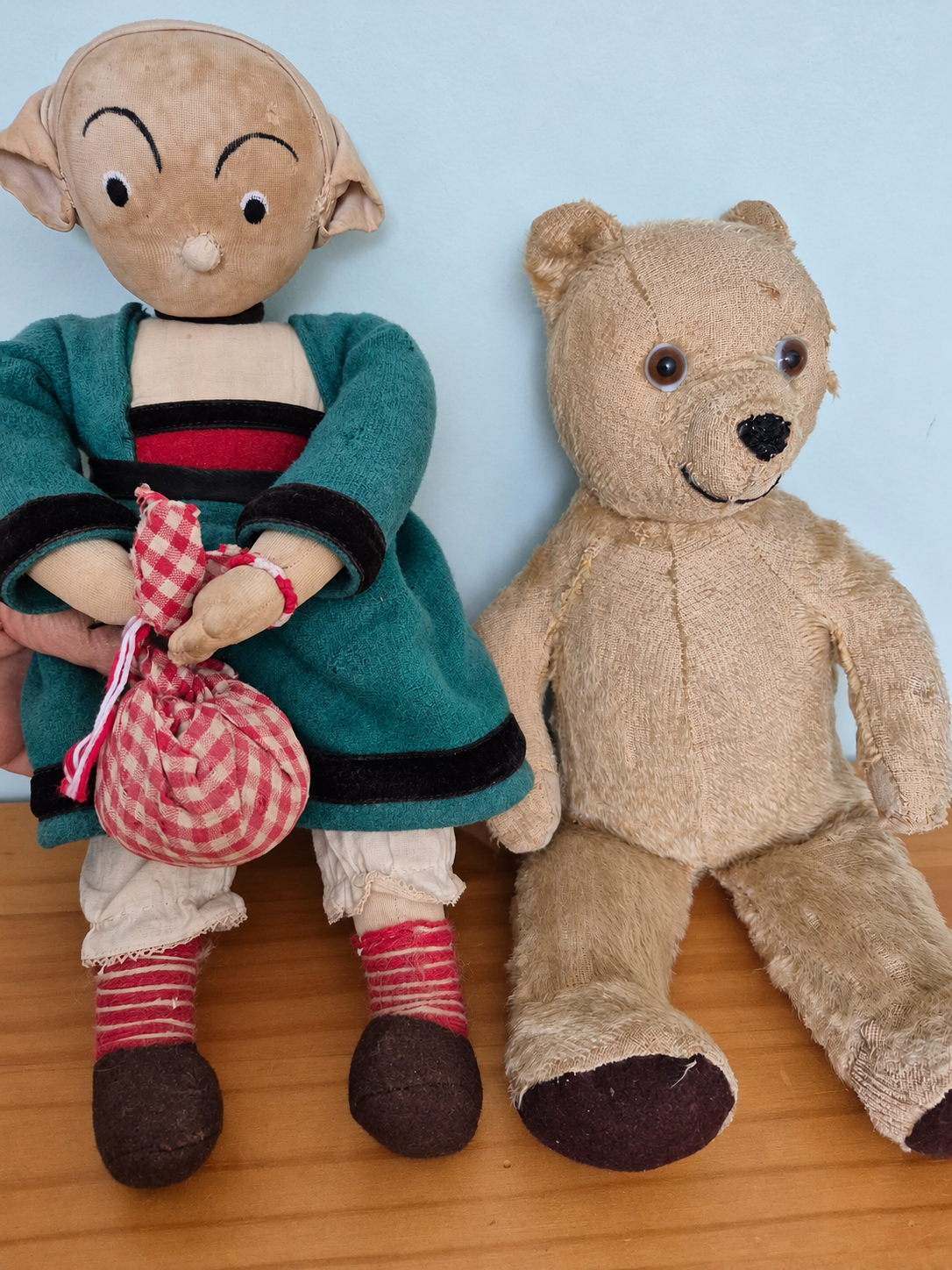 Raynal, Tintin et Bécassine — souvenirs de famille de Domi — Bécassine et le nounours Tintin, les compagnons de Domi : vêtement vert, baluchon à carreaux rouges et blancs et ours au textile usé ; image de présentation préparée numériquement — vue 2.