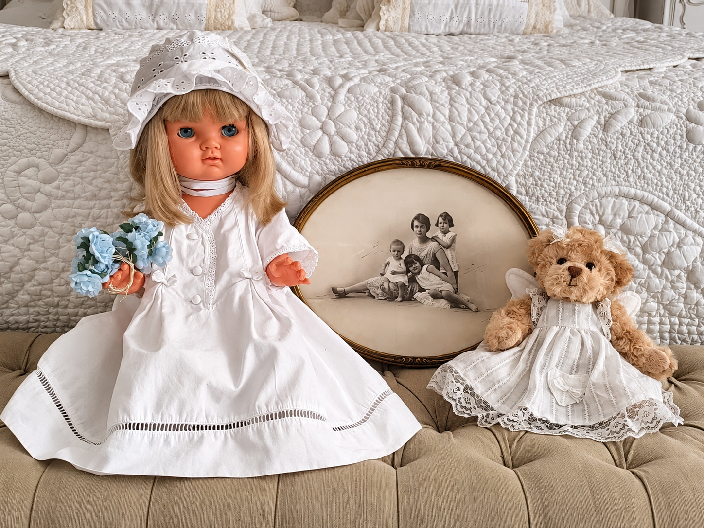 Suzie de Bella en robe blanche — collection de Jacqueline — Suzie de Bella de la collection de Jacqueline, en robe et bonnet blancs non d’origine, près d’un portrait ancien et d’un ourson. Photographie conservée sans retouche — vue 1.