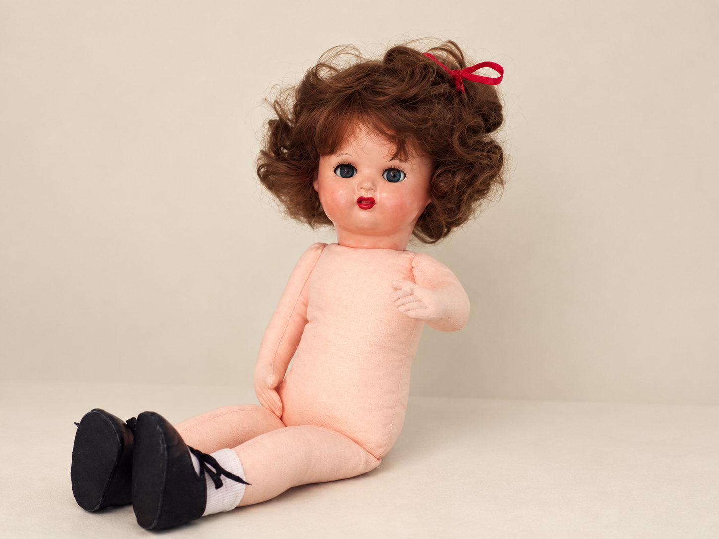 Une tête retrouvée, une poupée recréée — Femmes d’Aujourd’hui, collection de Françoise — La poupée de Françoise assise sans sa robe : corps, bras et jambes en tissu rose, tête réparée, perruque moderne, chaussettes et chaussures noires — vue 8.