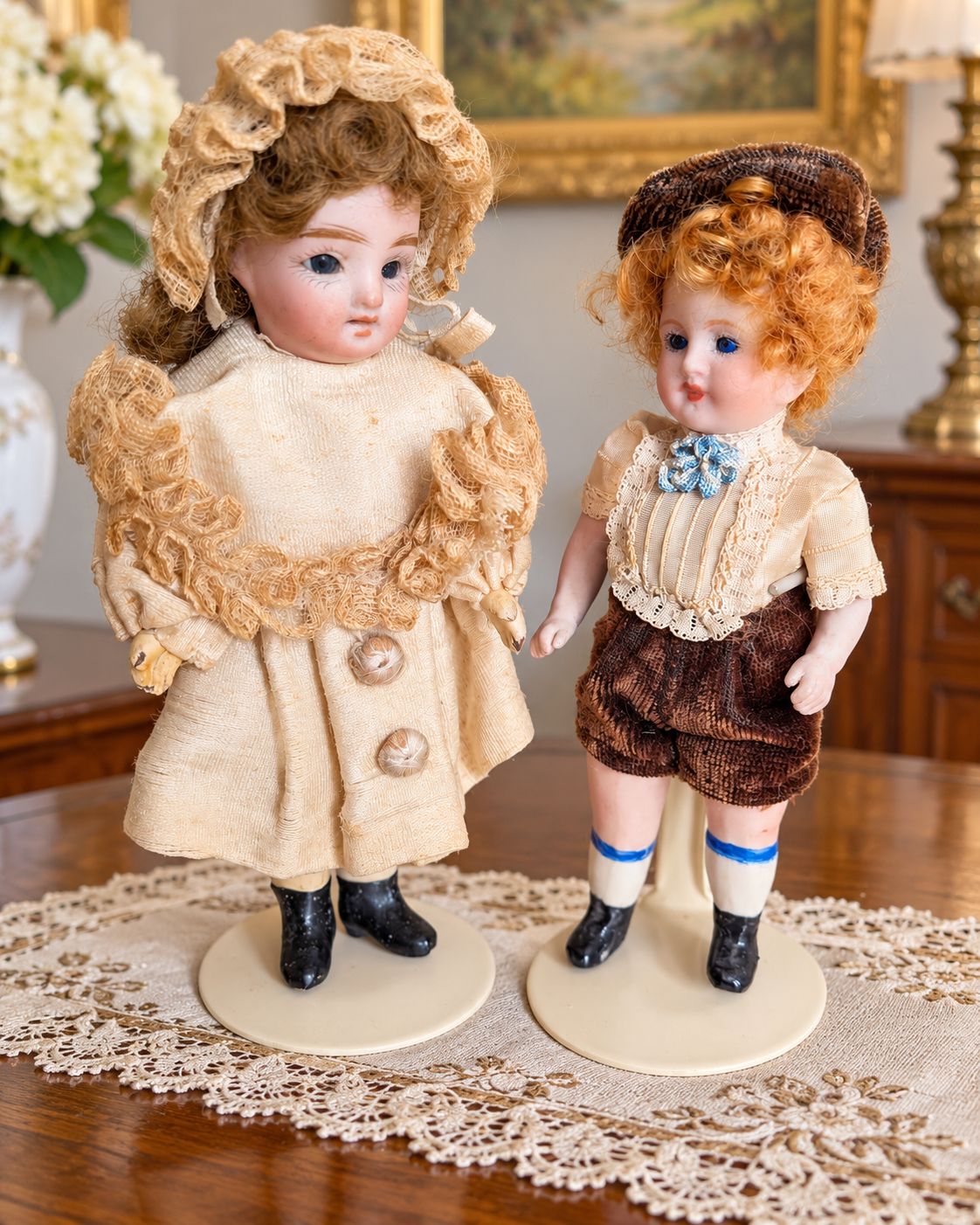 Mignonnettes anciennes : costumes et portraits — collection de Mireille (2/3) — Poupée en manteau crème à boutons et dentelles, près d’un petit personnage roux en casquette et culotte brunes — vue 4.