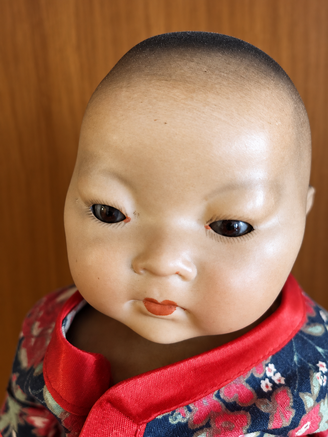 Bébé Armand Marseille, moule 353 — collection de Marie-Henriette — Portrait du bébé Armand Marseille, moule 353, de Marie-Henriette : cheveux peints en sombre, yeux sombres, bouche fermée et col rouge — vue 3.