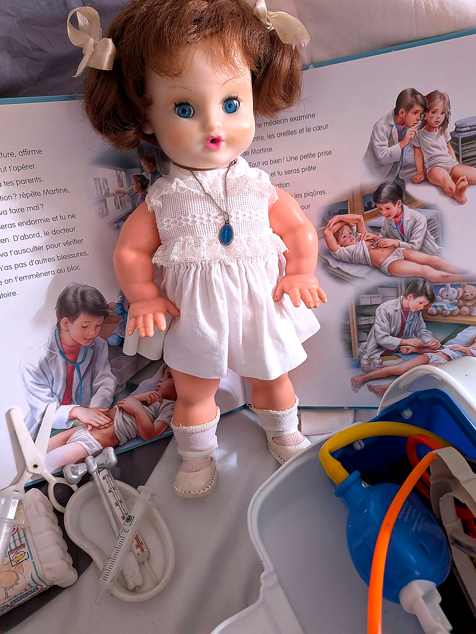 Bébé mouilleur et soigneur Bella, 32 cm — souvenir d’enfance de Mireille — Bébé Bella debout dans sa robe blanche — vue 4.