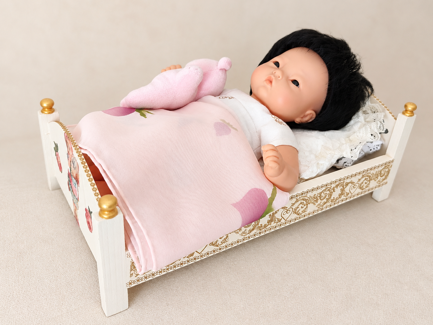 Un poupon Corolle offert par sa petite-fille en 2007 — collection de Martine — Le poupon Corolle de Martine, offert par sa petite-fille en 2007, présenté dans un lit miniature blanc avec dentelle, couverture et peluche roses — vue 1.
