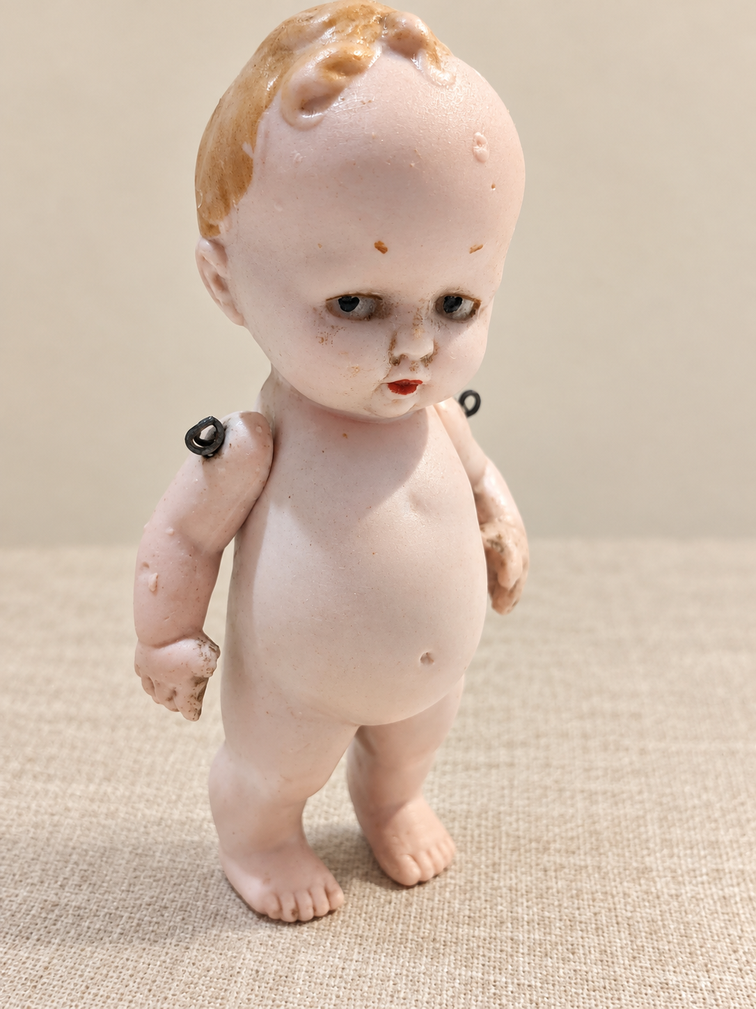 Bébé humoristique tout en porcelaine — collection de Mireille — Le bébé humoristique de Mireille, vu en entier de trois quarts — vue 1.