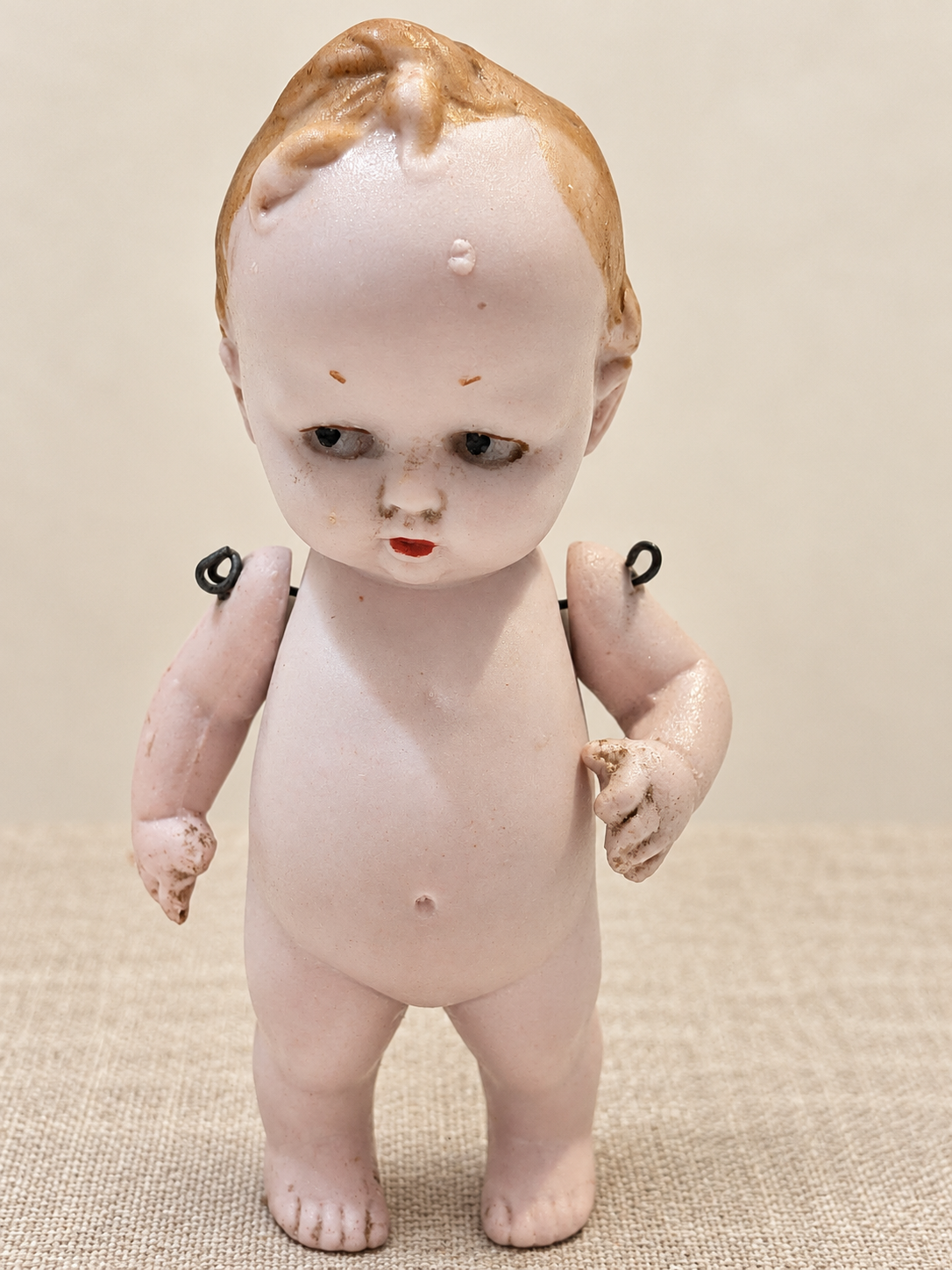 Bébé humoristique tout en porcelaine — collection de Mireille — Vue de face du bébé entier, avec les attaches des bras visibles — vue 4.